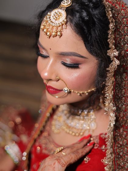 A serene close-up of a bride, highlighting her soft, shimmery eye makeup and the perfect red lip.