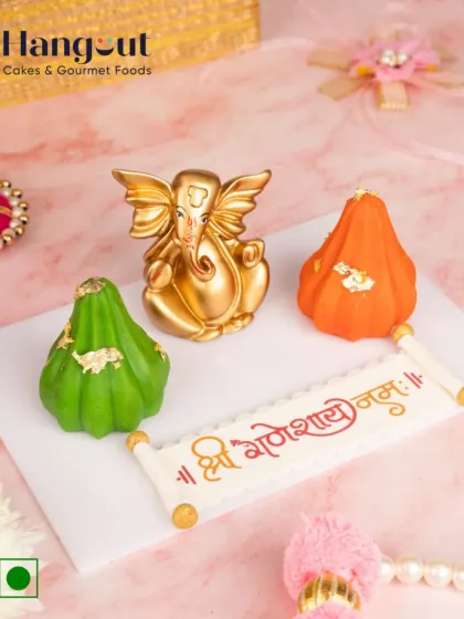 This Modak Hamper is filled with devotion and sweetness. It includes a Ganesh idol, a 'Shree Ganeshay Namah' message made of chocolate, and two festive modaks, making it a complete and thoughtful gift.