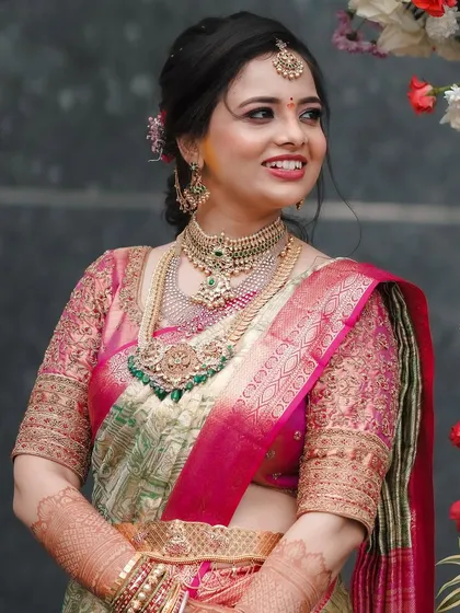 A bride in a pastel green and pink Kanchipuram saree. Her custom pink blouse is heavily embroidered, adding a touch of grandeur to her reception look.