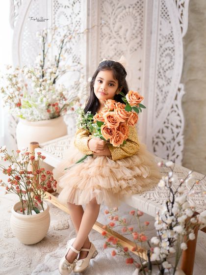 A portrait of a proud big sister holding a bouquet of flowers. Including individual shots of siblings during a family session makes them feel special.