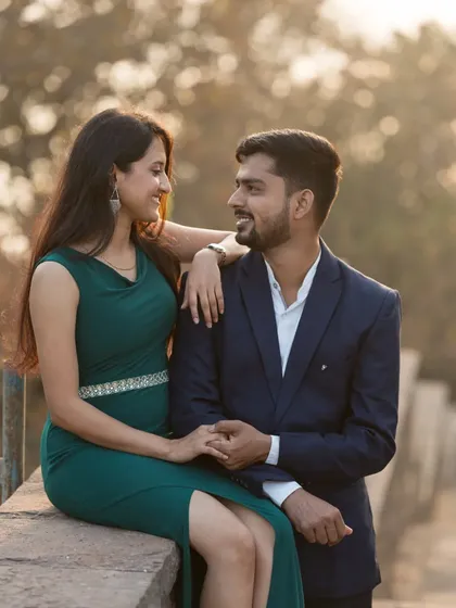 A sweet and relaxed portrait of a couple sitting together, sharing a smile during their outdoor pre-wedding session.