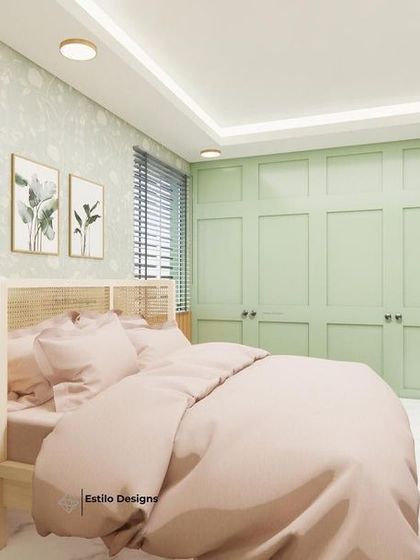 This view of the master bedroom highlights the blend of modern and cottage styles. The pastel green paneled wardrobe provides ample storage while adding a touch of color that complements the floral wallpaper and natural wood tones.