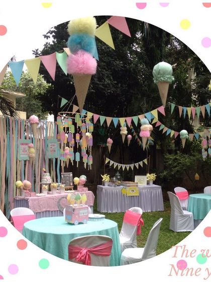 An overview of a pastel-colored ice cream themed party. The space was decorated with hanging ice cream cones and colorful buntings for a fun and festive feel.