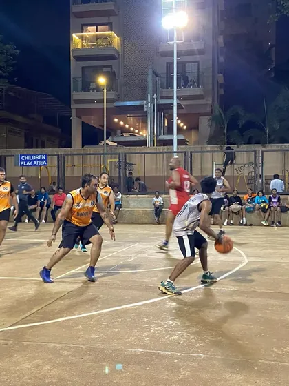 A player uses a crossover dribble to get past his defender in a men's eliminator game. Skill and strategy on full display.