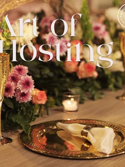 "Art of Hosting." Elegant gold-rimmed plates and hammered gold champagne flutes set on a beautifully decorated table. Our service includes providing luxury tableware to match the quality of our food.