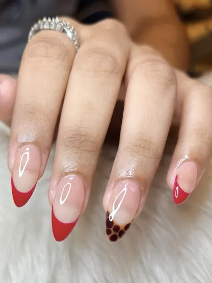 A unique take on the French manicure, combining bold red tips with a trendy tortoise shell accent nail. This design shows how you can mix and match different art styles for a custom look.