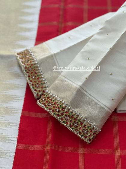 The sleeves of the off-white blouse, with a kemp-style border.