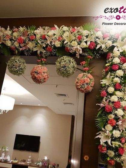 A sophisticated door frame decoration. We used white lilies, roses, and hanging floral balls in pastel shades to create a chic and elegant look for this home entrance.