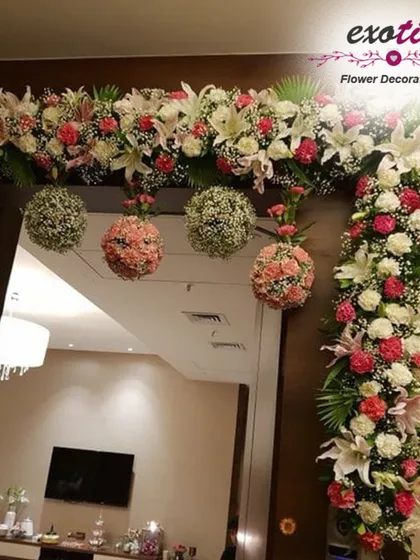 A sophisticated door frame decoration. We used white lilies, roses, and hanging floral balls in pastel shades to create a chic and elegant look for this home entrance.