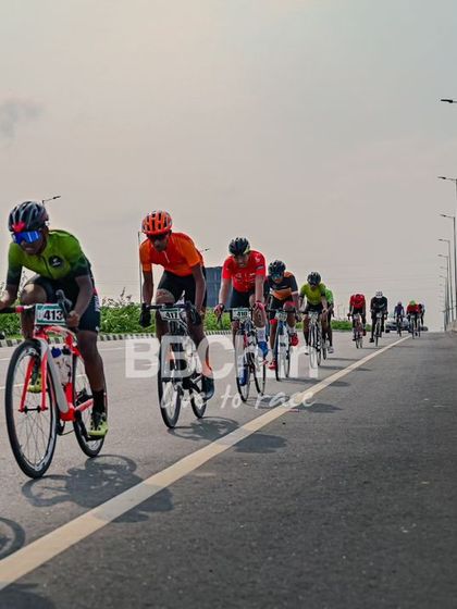 The peloton, a colorful and dynamic sight, races down the highway.