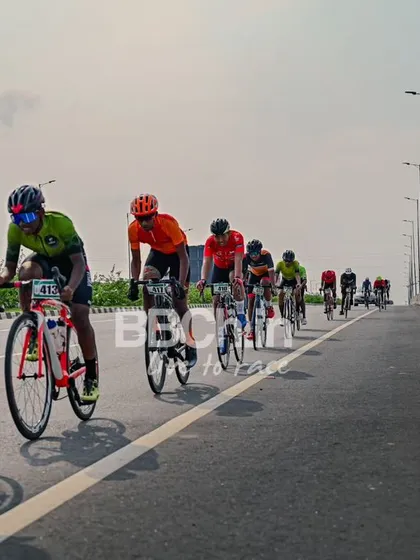 The peloton, a colorful and dynamic sight, races down the highway.