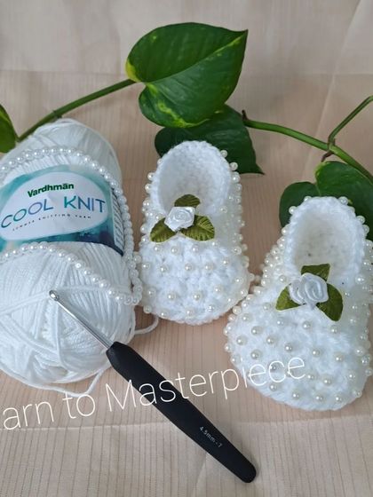 Here you can see the materials I use. This pair of pearl and rose booties is shown with the high-quality, soft Vardhman Cool Knit yarn I trust for my creations.