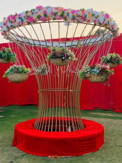 A custom-made decorative tree structure in gold, adorned with hanging flower baskets. This piece serves as a beautiful and unique decor element for any event.