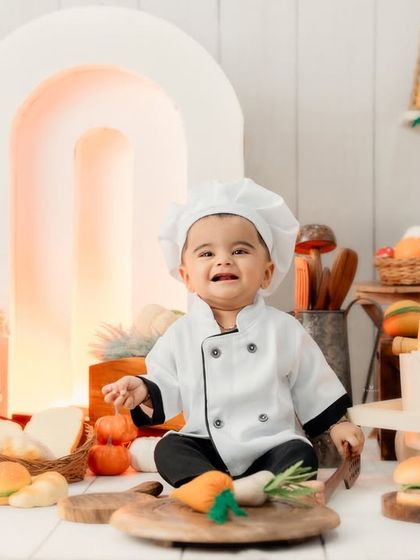 A big, happy smile from our head chef in his bakery-themed setup, complete with bread, pumpkins, and kitchen utensils.