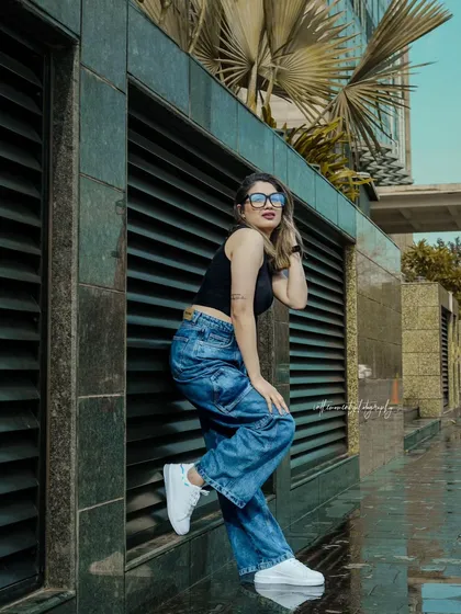 Playing with angles and leading lines against a modern building. The model's pose is dynamic, and the composition draws the eye, creating a visually interesting shot for a brand's lookbook.