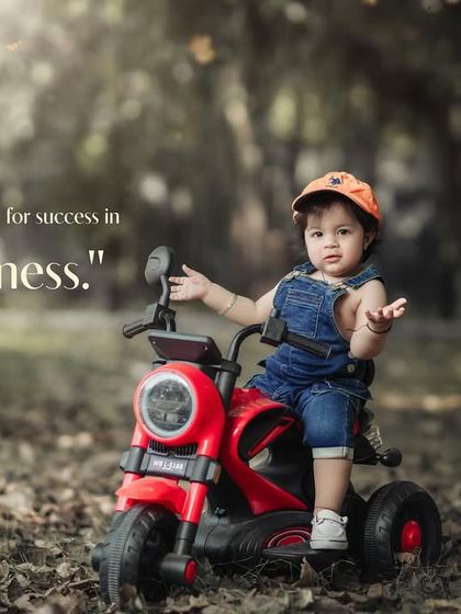 Dressed for success in pure happiness. A confident toddler poses on his toy motorcycle during an outdoor shoot.