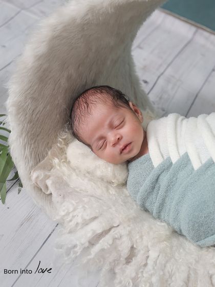 Dreaming on the moon. We use soft, textured props like this crescent moon to create magical and serene portraits of your sleeping newborn.
