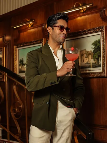 Enjoying a cocktail in our bottle green blazer. It's the perfect piece for bridging the gap between smart casual and formal.