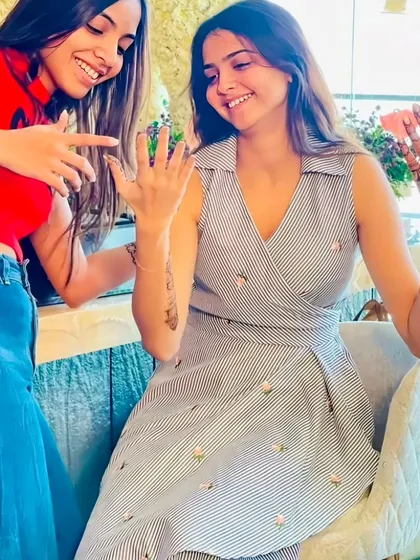 Friends admiring the fresh mehndi design at a party. It's always fun to share the excitement.