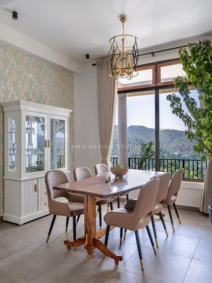 The dining area offers an unparalleled view, with a solid wood table and a white crockery unit, making every meal a special occasion.