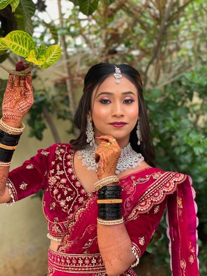 A close-up portrait of Pallavi, highlighting the intricate details of her makeup and henna. The look is both bold and elegant.