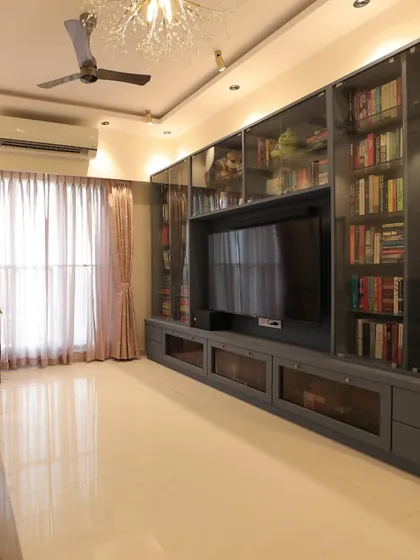 This is a great example of a TV unit that is also a library. I designed this full-wall unit with glass doors to store and display a large book collection, integrating the TV seamlessly into the design.