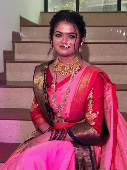 A close-up of the bride, showing the flawless makeup and the intricate details of her `Paithani` saree and jewelry.
