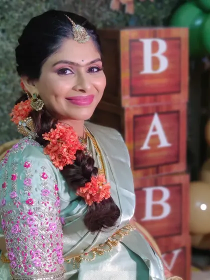 A close up of Keerthana's baby shower look. The focus was on clean skin, defined eyes, and a bright, happy lip color.