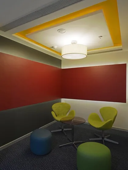 Bright primary colors add energy to this small meeting room. The space is designed for quick, informal chats and brainstorming sessions.