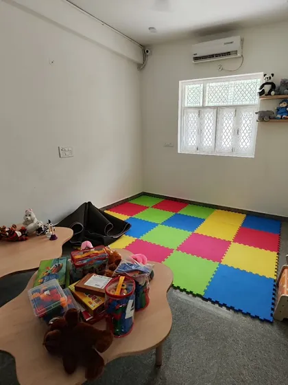 A dedicated play zone featuring soft, interlocking floor mats for safety. We created an open area for free play, with storage for toys on nearby shelves to keep the space tidy.