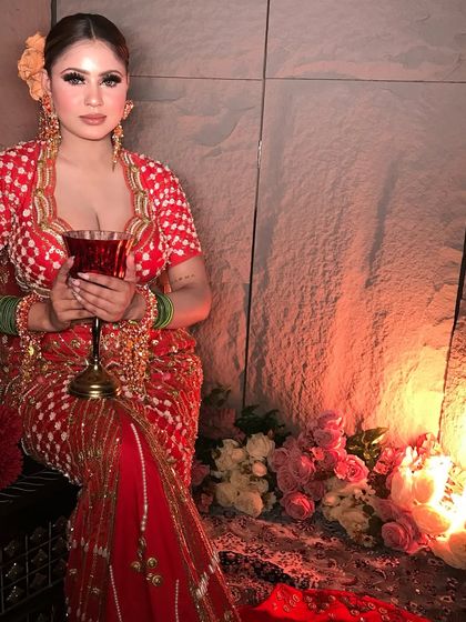 A contemporary look with a vintage feel. The model holds a wine glass, adding to the sophisticated and moody vibe of this red and orange ensemble.