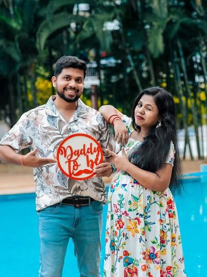 He's ready for his new role. This 'Daddy to be' prop adds a fun, interactive element to the couple's maternity shoot, capturing their shared excitement by the poolside.