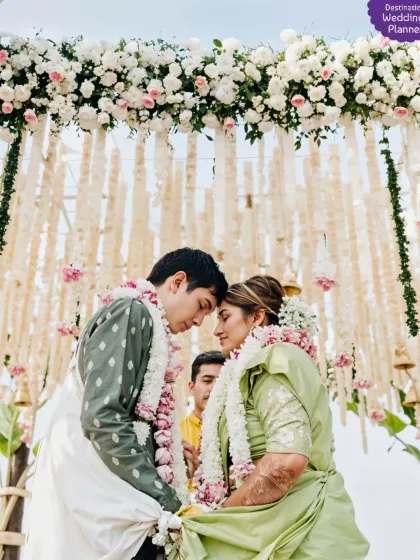 A beautiful, intimate moment between the couple during their wedding ceremony. The mandap featured a stunning ceiling of cascading floral hangings.
