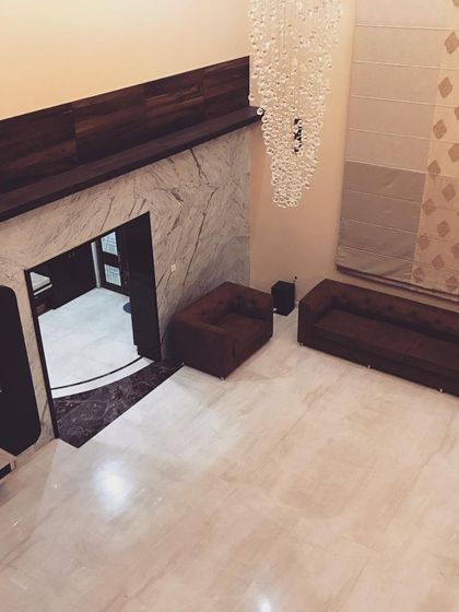 A duplicate of image 72, this top-down shot highlights the spaciousness of the living area and the contrast between the dark wood paneling and the light marble floor.