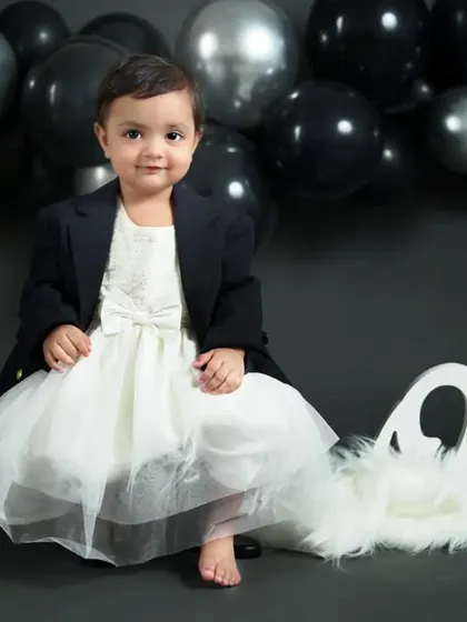 Black and white and cute all over. This elegant first birthday setup with black and silver balloons is the perfect backdrop for this little star.