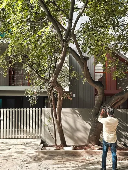 A view from the street shows how the renovated home now sits comfortably in its green surroundings. We streamlined the building's form and used a clean palette to create an inviting and contemporary feel.