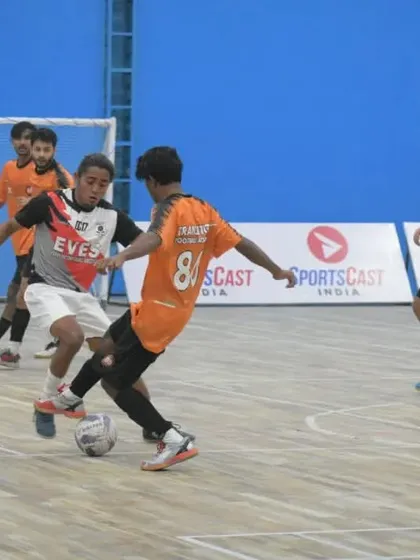 A skillful player takes on a defender in the Delhi Futsal League.