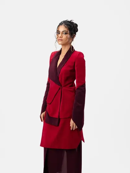 A side profile of the messy updo and clean makeup look for a designer lookbook. The hairstyle is intentionally undone to add a touch of softness to the sharply tailored outfit.