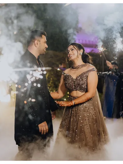 A magical Sangeet entrance for Dhwani and Aarshadd, surrounded by sparklers and smoke.