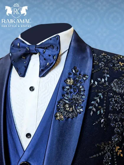 It's all in the details. This close-up highlights the exquisite hand-embroidery on the lapel of a navy blue tuxedo, paired with a custom-beaded bow tie. This is the level of craftsmanship I bring to every garment.