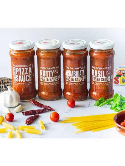 A lineup of various pasta sauces from The Gourmet Jar. This shot showcases the product range, styled with Italian-themed props to reinforce the brand's identity for e-commerce.