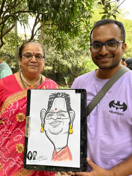 Posing with a guest and her caricature at The Farm Ecoville near Balewadi. The natural, rustic setting of the resort was a beautiful backdrop for this wedding event.