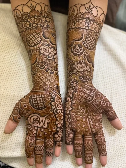 A beautiful three-quarter length Indian design that also includes the couple's initials, "N" and "W," on the palm. It is a popular way to personalize the bridal mehendi.