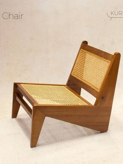 The 'N Chair' features a distinctive, low-profile geometric design. Crafted from solid teak with rattan panels, it's a comfortable and stylish addition for modern reading nooks and living spaces.