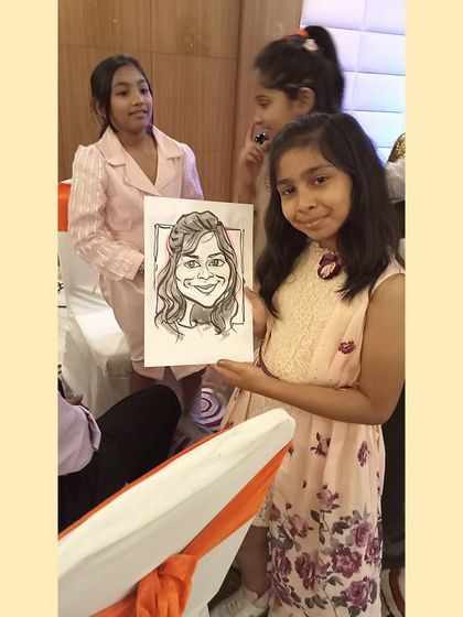 A young party guest holding up her finished portrait. The simple black and white sketch with a hint of color is my signature style.