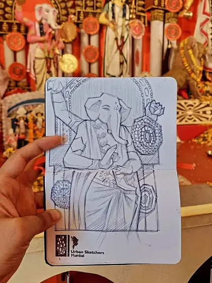 Live sketching at festivals allows me to capture the spirit of the celebration as it happens. Here is a ballpoint pen drawing of a Ganesha idol, sketched on-site at a local Durga Pooja pandal. The background shows the actual pandal, giving a sense of the lively environment I work in.