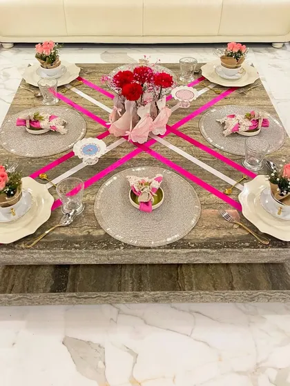 This perspective highlights the symmetry and balance of the pink ribbon theme. Each place setting is thoughtfully arranged with its own floral detail, contributing to a cohesive and elegant final look.