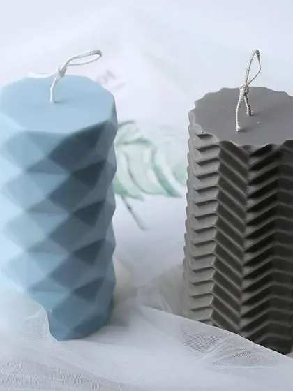 Modern and sophisticated. This image showcases two of my geometric pillar candle designs, a diamond-cut and a chevron pattern, in cool blue and grey tones.