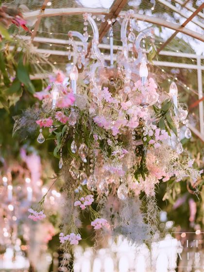 A crystal chandelier adorned with flowers and Spanish moss, hanging within the garden setting in Bali. This detail added a touch of glamour and whimsy to the natural surroundings.
