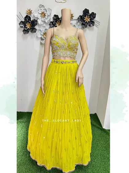 Brighten up any celebration with this vibrant yellow georgette lehenga. It's an ideal choice for a Haldi or Mehendi ceremony, with its light, flowy skirt and intricately embroidered bustier that allows for easy movement and beautiful photos.